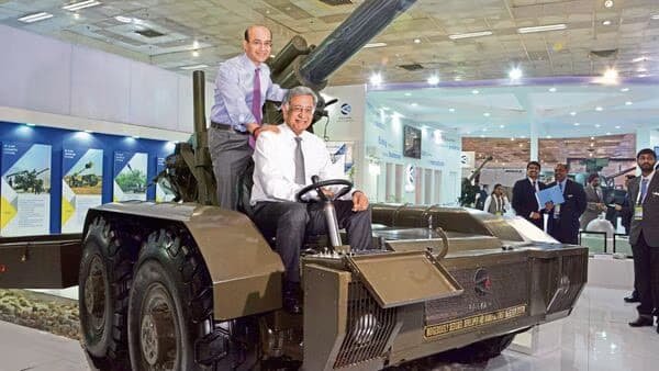 Photo featuring Amit B. Kalyani, standing in his role as joint managing director, and Baba Kalyani, seated as the chairman and managing director of Bharat Forge.. The company’s venture into the defense industry commenced in 2010.