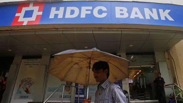 On the bustling streets of Mumbai, a customer is captured walking past an HDFC Bank branch, emphasizing the bank's strong presence in the financial hub.